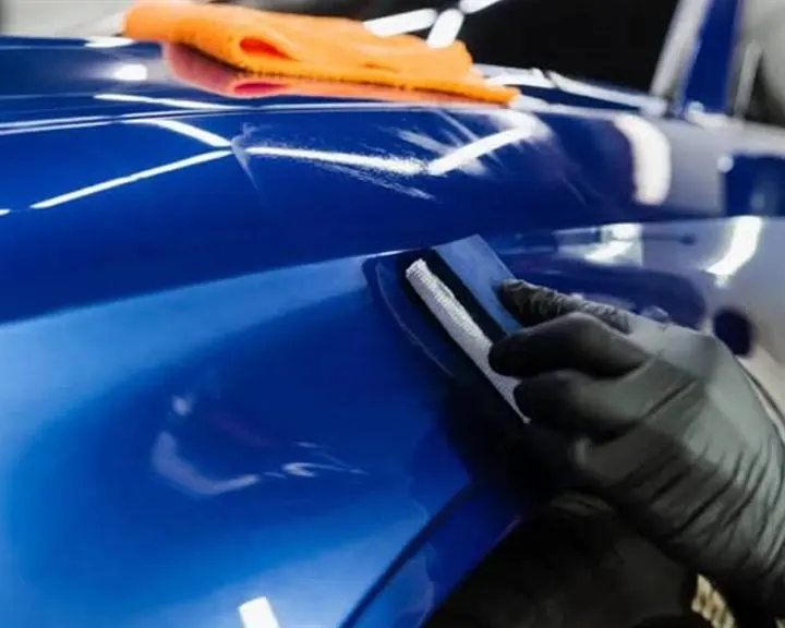 Ceramic coating being applied to a blue car panel