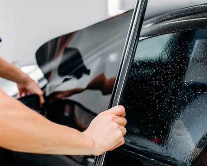 Sunfilm being fitted to a car window