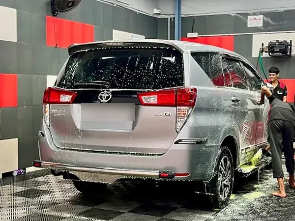 Silver SUV covered in foam during a car wash at the studio
